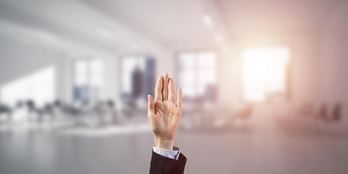 Close of businesswoman hand touching screen with finger and office at background