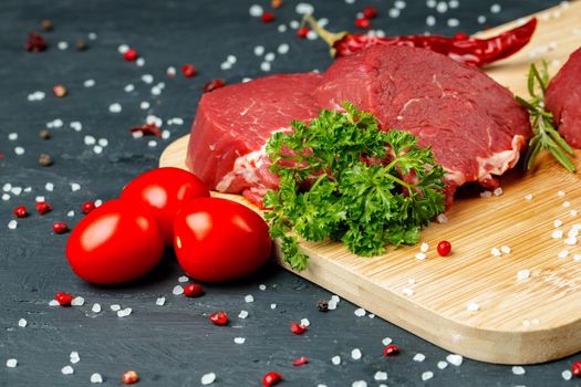 Slice of raw beef fillet on wooden board close up