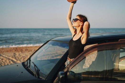 woman on the beach is with a car wearing sunglasses travel. High quality photo