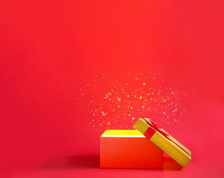 Open red gift box with a bow with a golden glow and glitter inside on a red background, banner, copyspace. universal holiday, christmas, valentine's day, new year, birthday, anniversary, present