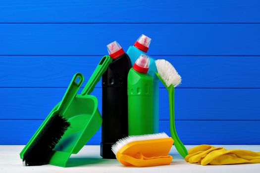Various cleaning items against blue wooden background, front view