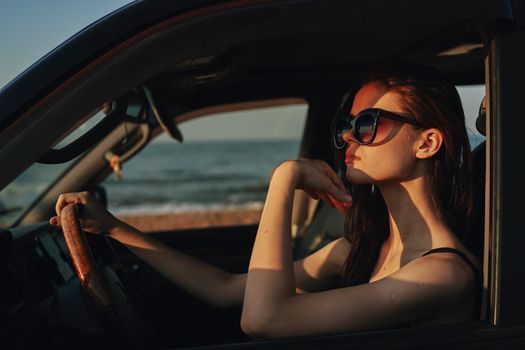 cheerful woman in sunglasses driving a car trip travel. High quality photo