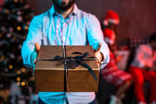 Christmas, x-mas, New year, winter, happiness concept - smiling man in santa helper hat with gift box. Funny people. Christmas party at home