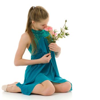 Adorable little girl in a beautiful dress posing in the studio with a cute bouquet of roses. The concept of a happy childhood, holiday. isolated on a white background.