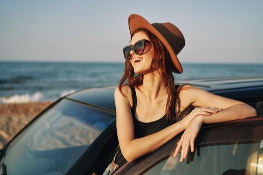 woman on the beach is with a car wearing sunglasses travel. High quality photo
