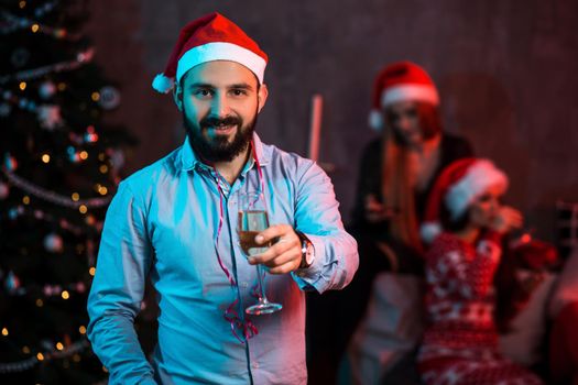 Christmas, x-mas, New year, winter, happiness concept - smiling man in santa helper hat with a glass of champagne. Funny people. Christmas party at home