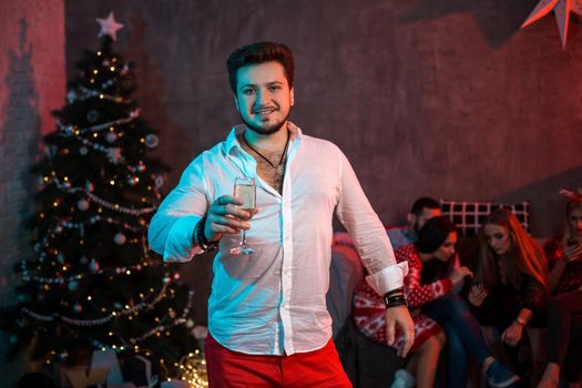 Christmas, x-mas, New year, winter, happiness concept - smiling man with a glass of champagne. Funny people. Christmas party at home