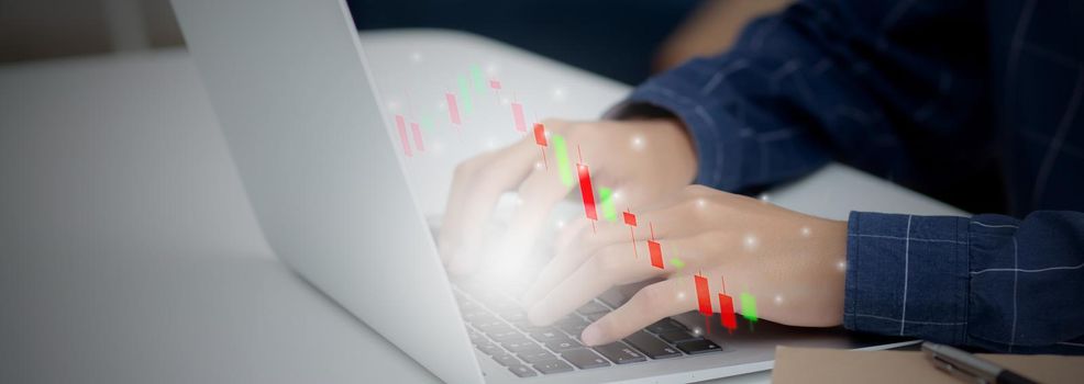 Hands of businessman using laptop computer having graph of investment with risk stock and funds virtual on desk, marketing for strategy and planning for success, business futuristic concepts.