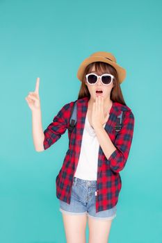 Beautiful portrait young asian woman surprise wearing sunglasses and hat travel summer fashion with tourist isolated on blue background, girl shocked expression and emotion, holiday amazing concept.