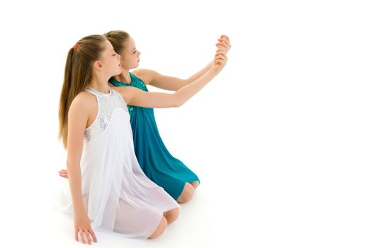 Pretty Gymnasts Performing Rhythmic Gymnastics Exercise, Two Beautiful Teen Sisters Dancing Wearing Sport Dresses, Two Girls Posing in Studio Against White Background