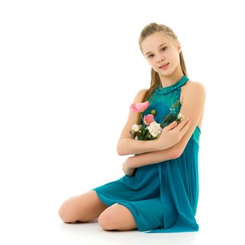 Adorable little girl in a beautiful dress posing in the studio with a cute bouquet of roses. The concept of a happy childhood, holiday. isolated on a white background.