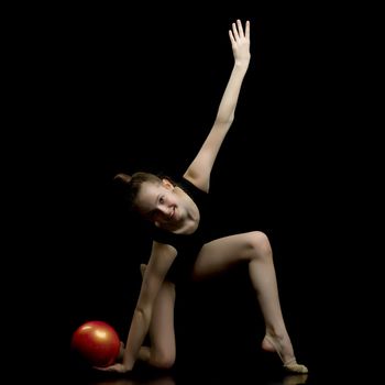 Beautiful little girl gymnast performs exercises with the ball. The concept of children's sports, fitness. Isolated