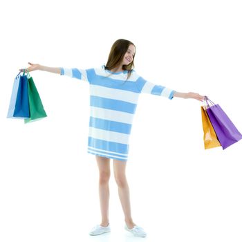 Beautiful teen girl shopping in a store. With large paper bags in hand. The concept of holiday sales, advertising products. Isolated on white background.