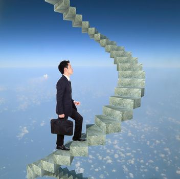 business man going upstairs in a curved staircase to success with blue sky background