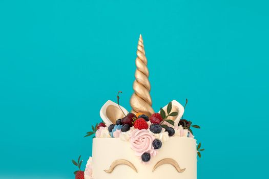 Unicorn cake with copy space to side on blue background