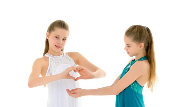 Two adorable girls gymnasts folded hands in the form of a heart. Sign of love. Isolated on a white background.