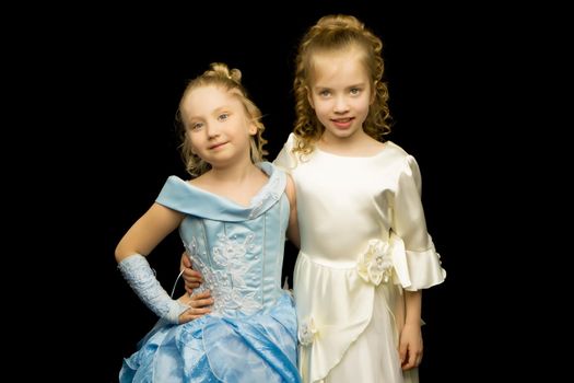 Two cute little girls in full growth, in the studio on a white background. The concept of a happy childhood, Beauty and fashion. Isolated.