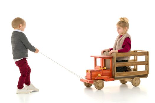 Brother and sister are playing with a toy car. The concept of happy childhood, people, harmonious development of the child in the family. Isolated on white background.