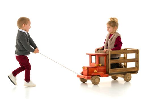 Brother and sister are playing with a toy car. The concept of happy childhood, people, harmonious development of the child in the family. Isolated on white background.