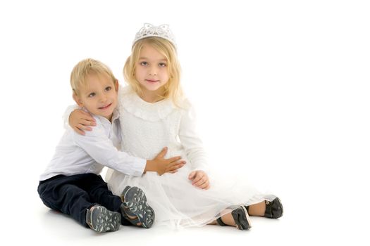 Boy and girl, brother and sister posing in the studio. Concept of family values, friendship, game. Isolated on white background