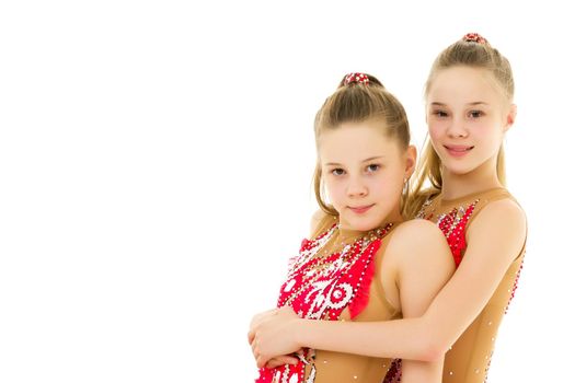Pretty Gymnasts Performing Rhythmic Gymnastics Exercise, Two Beautiful Teen Sisters Dancing Wearing Sport Dresses, Two Girls Posing in Studio Against White Background