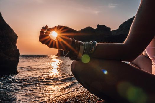 Young woman in swimsuit with long hair practicing stretching outdoors on yoga mat by the sea on a sunny day. Women's yoga fitness pilates routine. Healthy lifestyle, harmony and meditation concept.