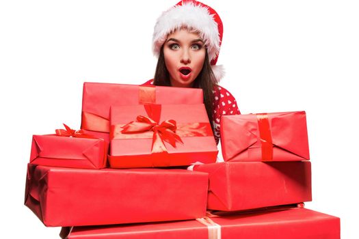 Young woman in sweater and christmas hat holding gift boxes isolated on white background. Christmas sale. Emotional brunette. Copy space