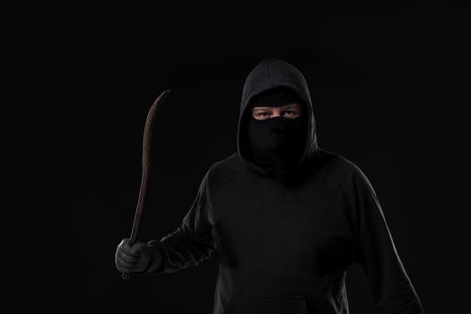 Male offender masked with a scrap. On black background at the studio. Breaking. A crime. Bandit and thief