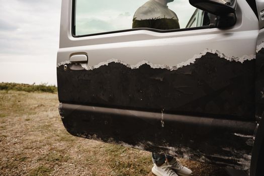 Gray off-road car stopped with open door, close up