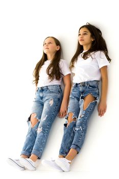 Two beautiful little girls in the studio, happy childhood concept.