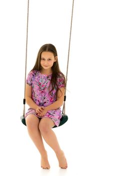 School-age teenage girl swinging on a swing. The concept of rest after class. Isolated on white background.