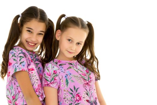 Two cute little girls close-up, in the studio on a white background. The concept of a happy childhood, Beauty and fashion. Isolated.