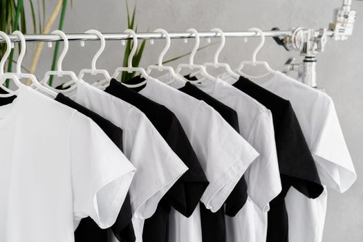 Row of black and white t-shirts hanging on rack, close up