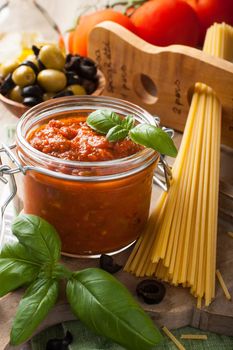 Traditional homemade tomato sauce with spaghetti and ingredients. Italian healthy food background. View from above.