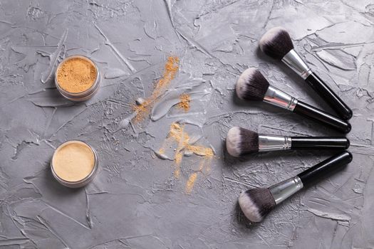 Mineral powder of different colors with a brushes for make-up on wooden background