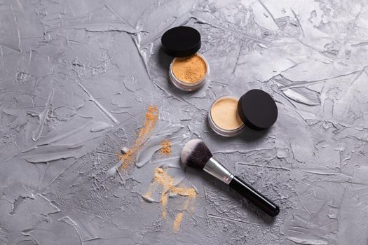 Mineral powder of different colors with a brushes for make-up on wooden background