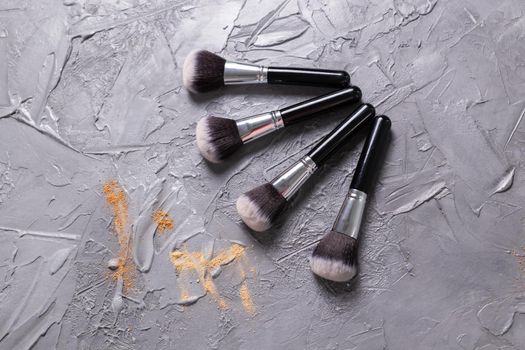 Mineral powder of different colors with a brushes for make-up on wooden background