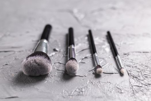 Top view of make-up brushes on grey background.