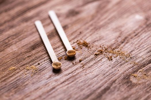 Mineral powder of different colors with spoon dispenser for make-up on wooden background.