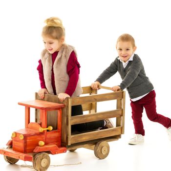 Brother and sister are playing with a toy car. The concept of happy childhood, people, harmonious development of the child in the family. Isolated on white background.