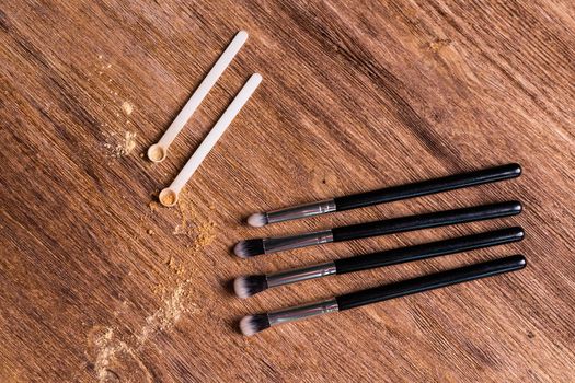 Mineral powder foundation with brush on a wooden background.