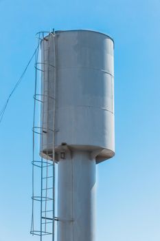 Water tower water storage tank at a height against the blue sky.