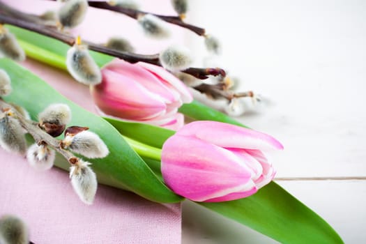 Easter composition with pink tulips on white wooden background