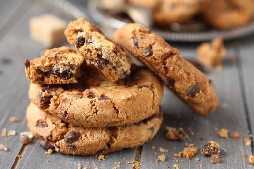 Stacked chocolate chip cookies on rustic wooden background