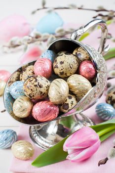 Colorful chocolate easter eggs in metal vase - easter composition