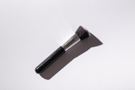 Make-up brush on white background, top view. Cosmetics, beauty and skin care concept