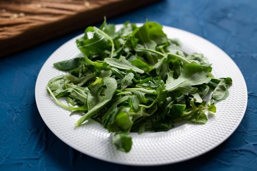 Fresh arugula salad on a plate. Concept of dieting or detox or vegetarian.