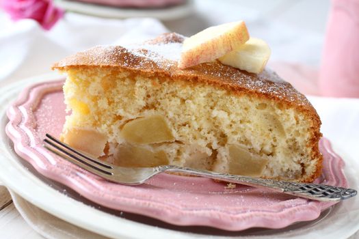 Slice of homemade apple sponge cake on pink plate