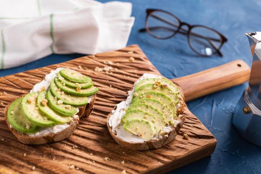 Avocado sandwich on dark rye bread made with fresh sliced avocados from above