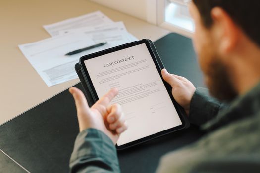 Close up businessman signing loan contract on tablet at office.Concept of filling documents.